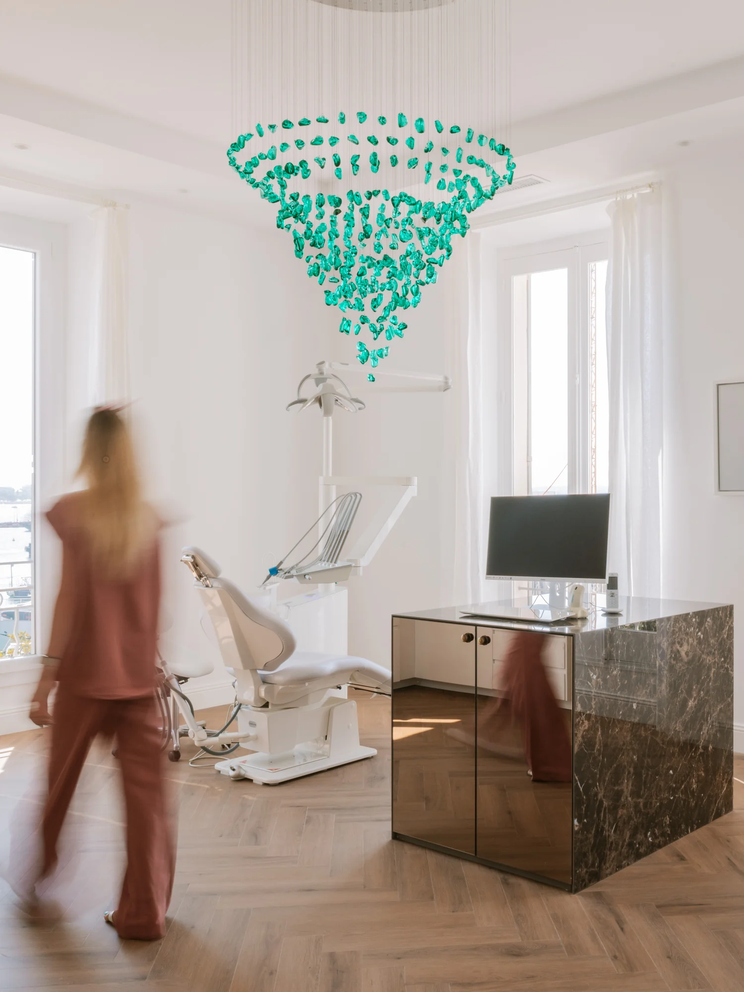 Salle de soins sous le lustre de verre vert, face aux fenêtres sur le Vieux Port